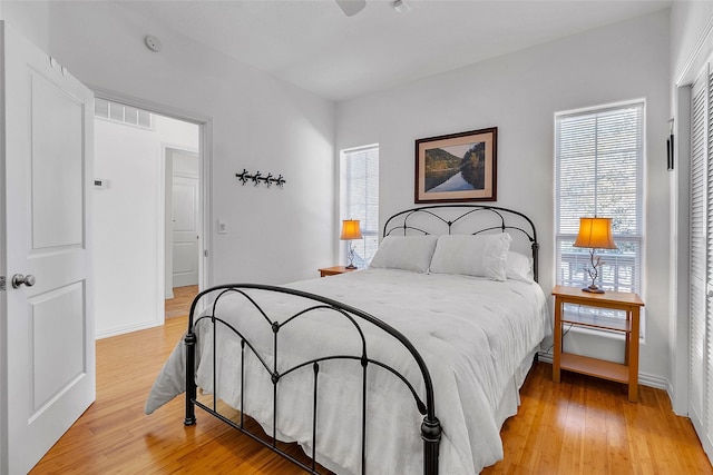 bedroom featuring visible vents, light wood finished floors, and baseboards