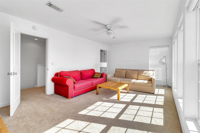 living area with visible vents, carpet flooring, baseboards, and ceiling fan