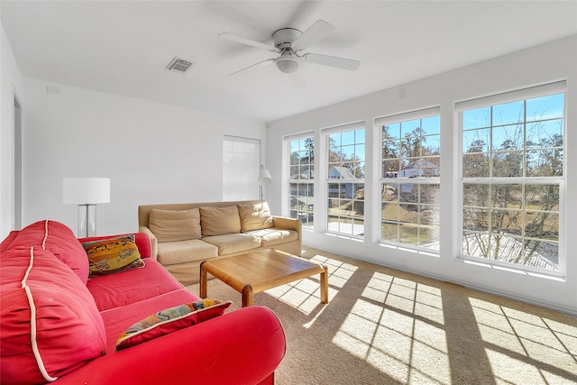 living area with a ceiling fan, visible vents, and carpet flooring
