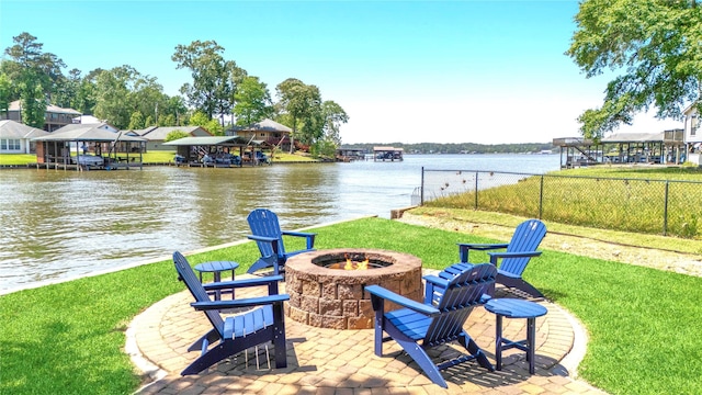 view of patio / terrace with a fire pit, a water view, and fence