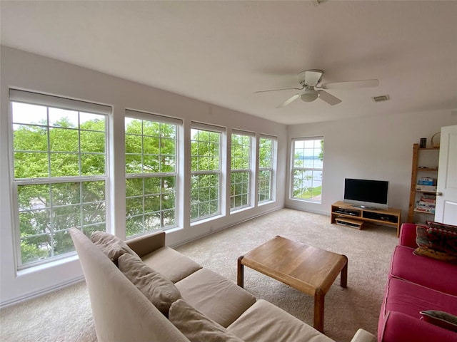 living room featuring visible vents, carpet flooring, and ceiling fan