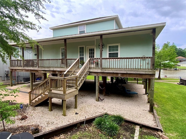 rear view of property with stairway, central AC unit, covered porch, a carport, and a lawn