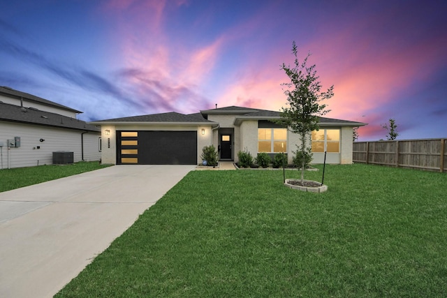 prairie-style home with fence, a garage, cooling unit, a lawn, and driveway
