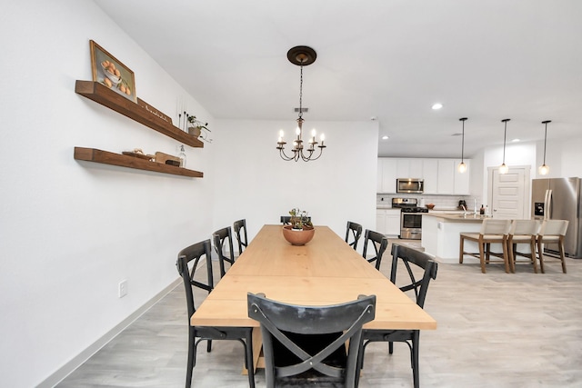 dining space with recessed lighting, baseboards, a chandelier, and light wood-style flooring