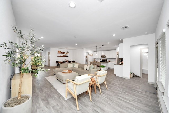 living area featuring recessed lighting, visible vents, and light wood-style flooring