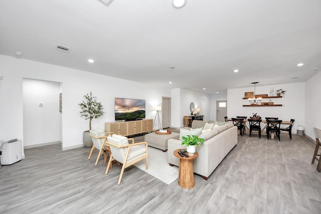 living room featuring recessed lighting, a notable chandelier, visible vents, and light wood-style flooring