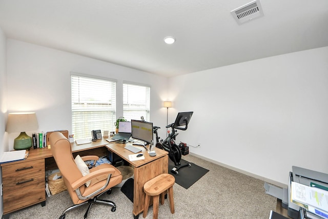 carpeted office space featuring baseboards and visible vents