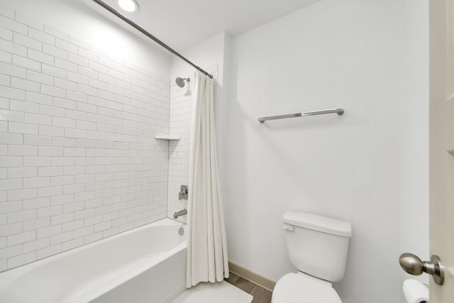 full bathroom with baseboards, wood finished floors, shower / bath combination with curtain, and toilet