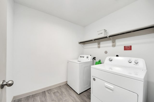 laundry room with light wood-style floors, baseboards, laundry area, and washing machine and clothes dryer