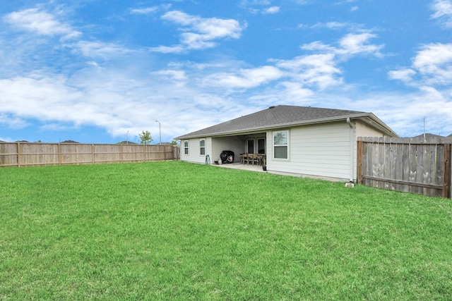 rear view of house with a patio, a fenced backyard, and a lawn