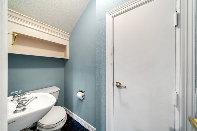 1002 Island Vw, League City, TX 77565 - bathroom featuring tile patterned flooring, toilet, a sink, baseboards, and a textured ceiling