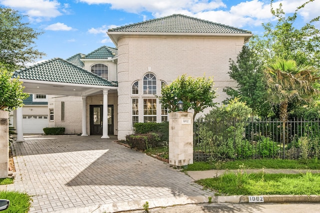 1002 Island Vw, League City, TX 77565 - view of front of house with fence, a tiled roof, decorative driveway, brick siding, and a garage