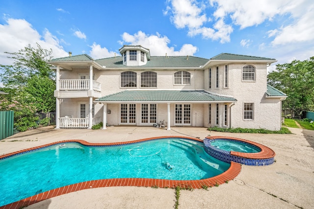 1002 Island Vw, League City, TX 77565 - rear view of property with a tiled roof, a balcony, a patio area, french doors, and a pool with connected hot tub