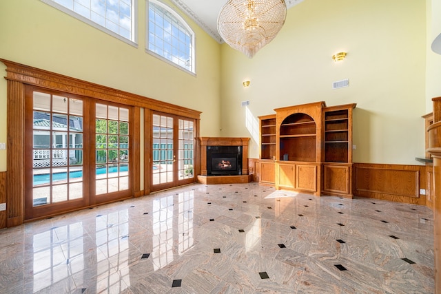 1002 Island Vw, League City, TX 77565 - unfurnished living room with a high ceiling, an inviting chandelier, visible vents, and plenty of natural light