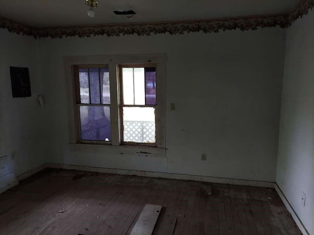 empty room featuring hardwood / wood-style floors and baseboards