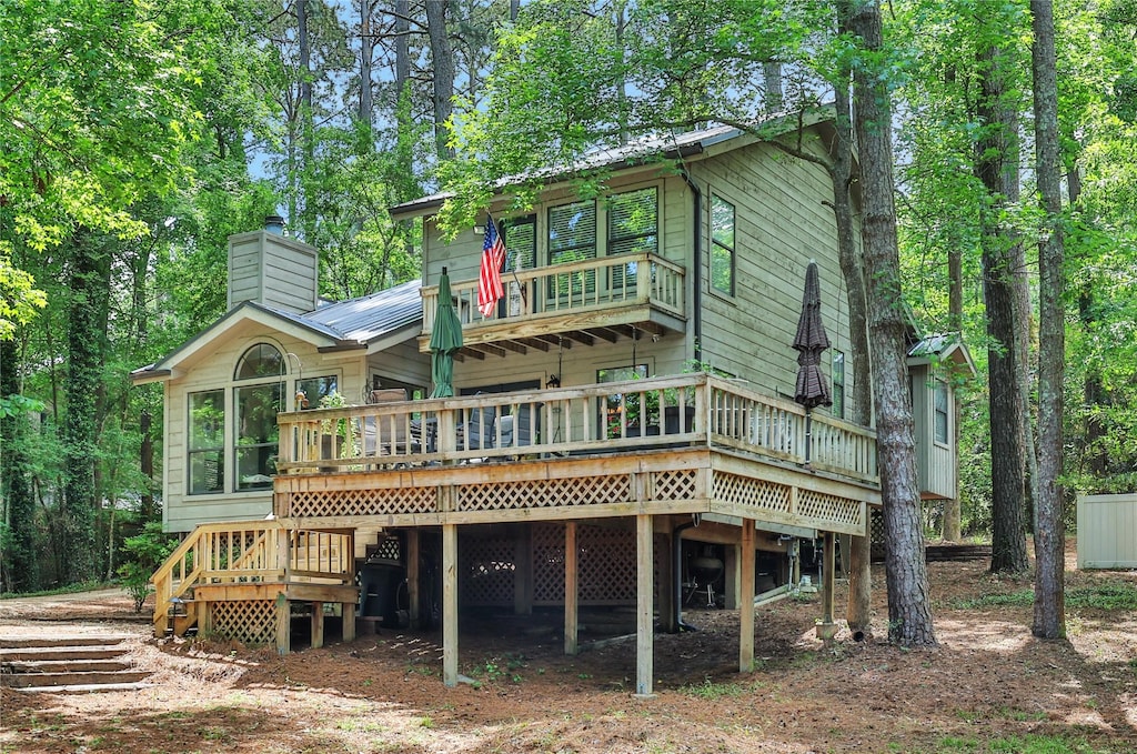 1103 Lakeview Estates Dr, Coldspring, TX 77331 - rear view of house with a chimney, a deck, and metal roof