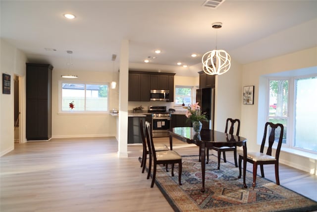 dining area with light wood-style floors, visible vents, and baseboards