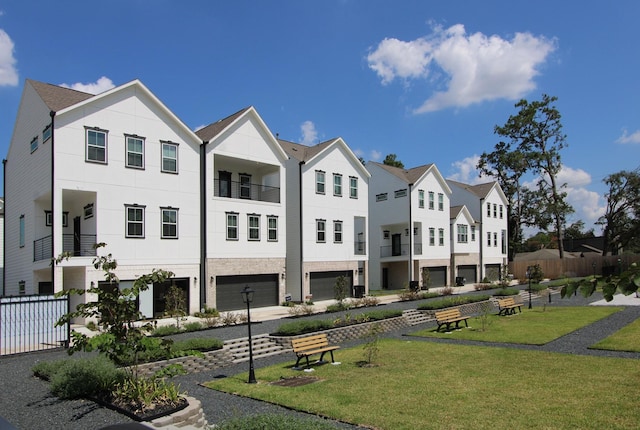 exterior space featuring a lawn, fence, a residential view, and a garage