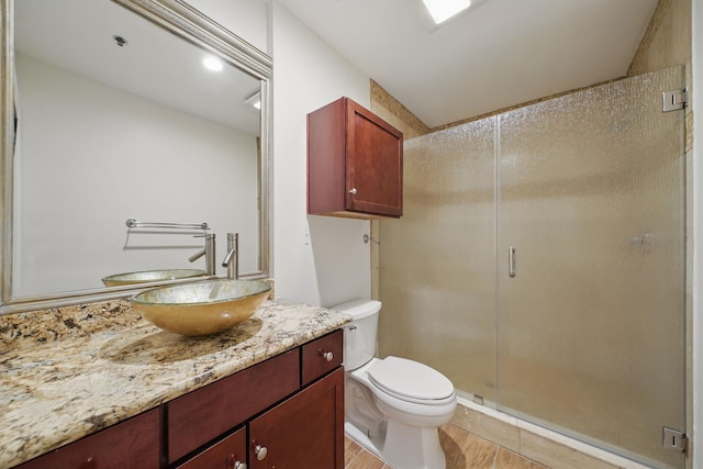 bathroom with a shower stall, toilet, and vanity