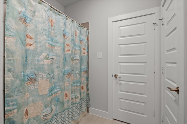 bathroom with curtained shower and baseboards