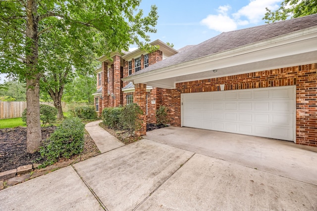 view of property exterior with brick siding, driveway, and roof with shingles