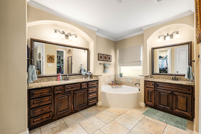 full bath with two vanities, a bath, a sink, and ornamental molding