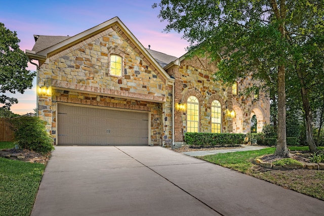 view of front facade featuring stone siding, a garage, and concrete driveway