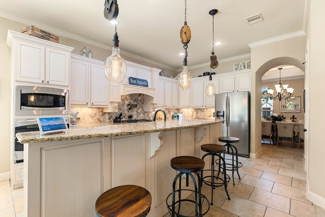 kitchen with stainless steel appliances, backsplash, visible vents, crown molding, and a kitchen island with sink