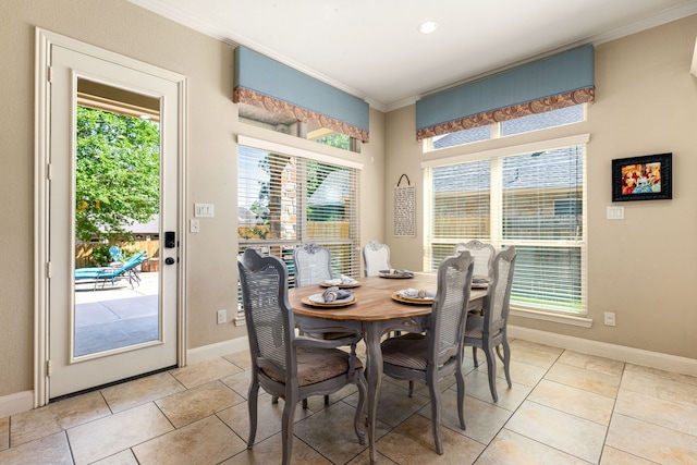 dining room featuring light tile patterned floors, baseboards, ornamental molding, and plenty of natural light