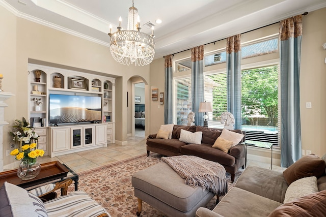 living area with an inviting chandelier, a tray ceiling, visible vents, ornamental molding, and arched walkways