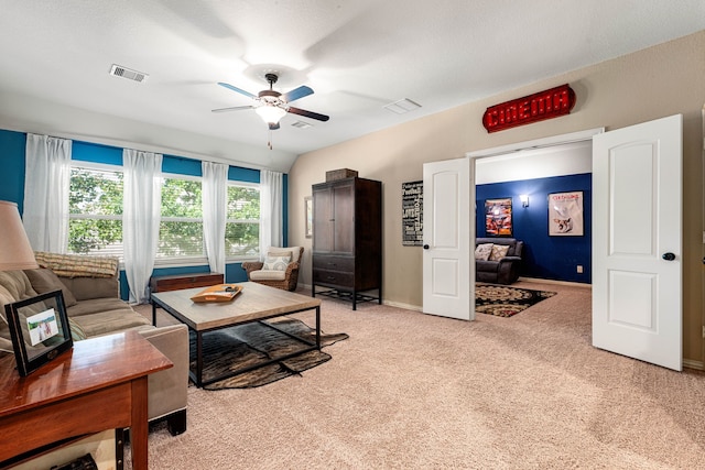 living area featuring ceiling fan, baseboards, visible vents, and light colored carpet
