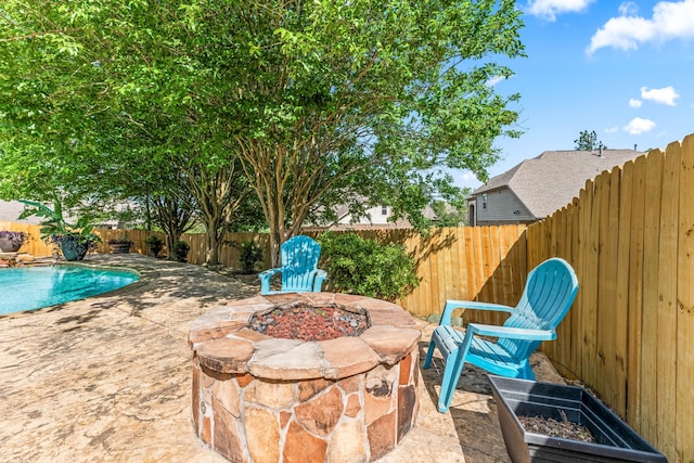 view of patio / terrace with a fenced in pool, a fenced backyard, and an outdoor fire pit