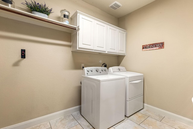 washroom featuring visible vents, light tile patterned flooring, baseboards, washer and dryer, and cabinet space