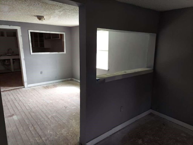 108 E Mcgee Rd, New Boston, TX 75570 - unfurnished room with wood finished floors, baseboards, and a textured ceiling