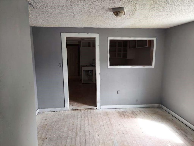 108 E Mcgee Rd, New Boston, TX 75570 - spare room with hardwood / wood-style floors, baseboards, and a textured ceiling