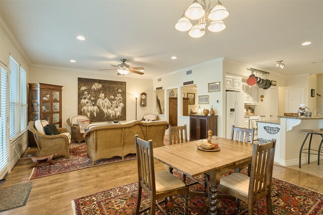 102 Capetown Slip, Conroe, TX 77356 - dining space with light wood-style floors, recessed lighting, a chandelier, a ceiling fan, and crown molding