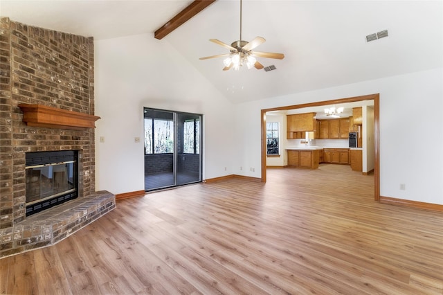 110 Dickens Landing Dr, Livingston, TX 77351 - unfurnished living room with visible vents, a fireplace, beamed ceiling, baseboards, and light wood finished floors