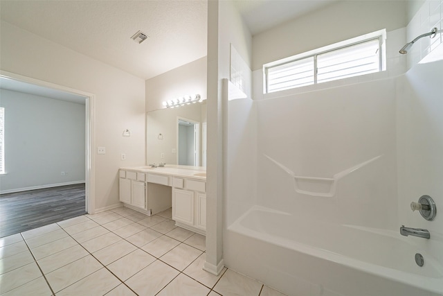bathroom with tile patterned floors, vanity, bathtub / shower combination, baseboards, and visible vents