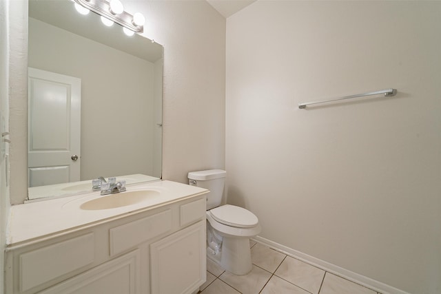 half bathroom with toilet, vanity, tile patterned floors, and baseboards