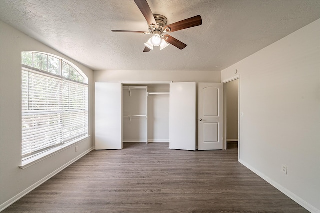 unfurnished bedroom with a closet, wood finished floors, a textured ceiling, and baseboards