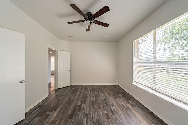 spare room with visible vents, a ceiling fan, baseboards, and dark wood-style flooring