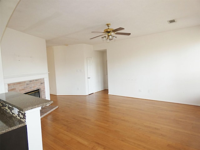 3015 Davey Oaks St, Pearland, TX 77584 - unfurnished living room featuring light wood-style flooring, a ceiling fan, and a fireplace