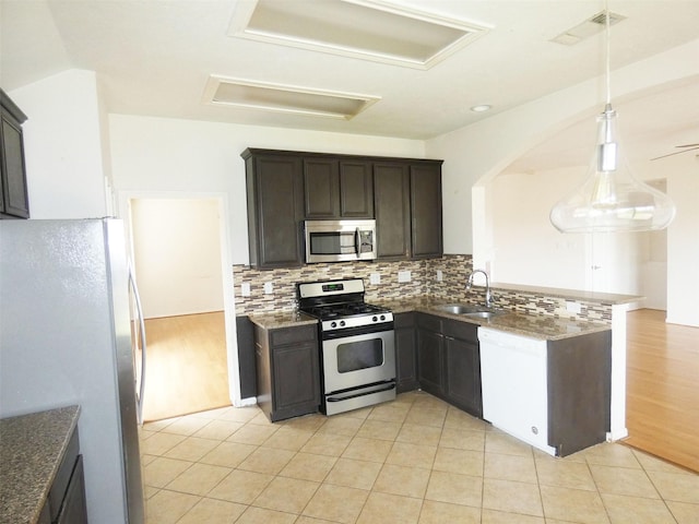 3015 Davey Oaks St, Pearland, TX 77584 - kitchen with appliances with stainless steel finishes, a sink, arched walkways, decorative backsplash, and dark stone countertops