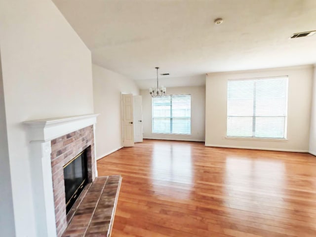 3015 Davey Oaks St, Pearland, TX 77584 - unfurnished living room with light wood-style floors, a chandelier, a fireplace, and baseboards
