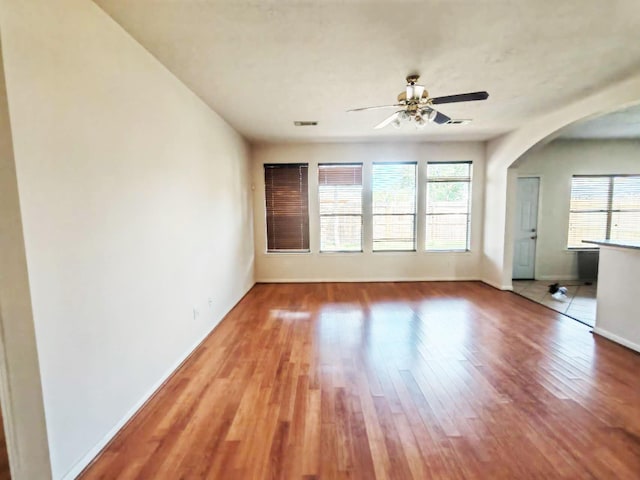 3015 Davey Oaks St, Pearland, TX 77584 - unfurnished living room with healthy amount of natural light, wood finished floors, baseboards, and arched walkways