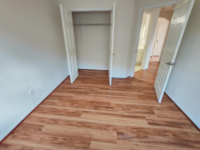 3015 Davey Oaks St, Pearland, TX 77584 - unfurnished bedroom with light wood-type flooring, arched walkways, and a closet