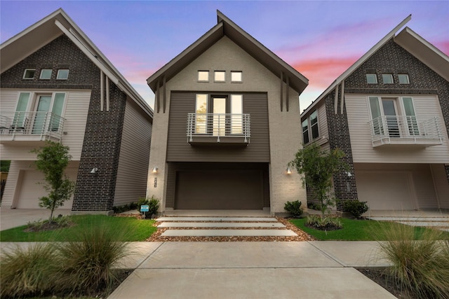1044 Homer St, Houston, TX 77091 - view of front of property with a balcony, a garage, brick siding, and concrete driveway
