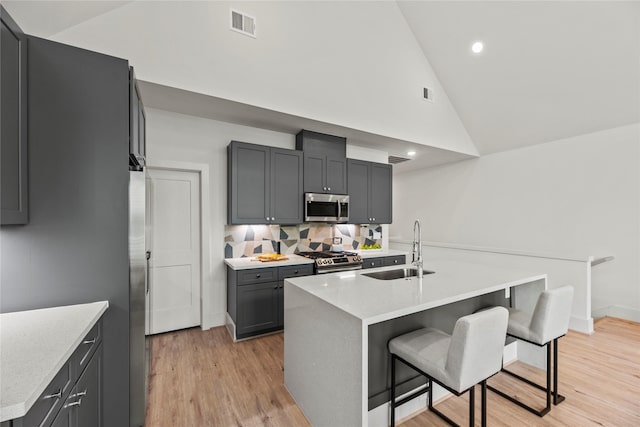 1044 Homer St, Houston, TX 77091 - kitchen featuring stainless steel appliances, a sink, high vaulted ceiling, a breakfast bar, and light countertops