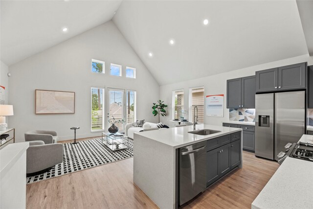 1044 Homer St, Houston, TX 77091 - kitchen featuring appliances with stainless steel finishes, open floor plan, a sink, high vaulted ceiling, and light countertops