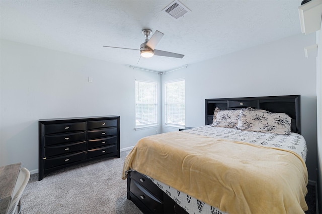 carpeted bedroom featuring baseboards, a ceiling fan, a textured ceiling, and visible vents